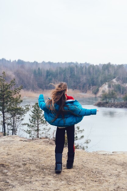 Mujer hermosa joven que presenta en un lago