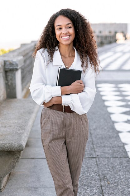 Mujer hermosa joven que sostiene un libro