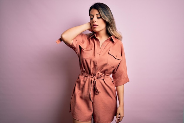 Mujer hermosa joven con ropa urbana de moda modelo con estilo casual de calle de pie sobre fondo rosa