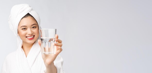 Mujer hermosa joven saludable agua potable belleza cara maquillaje natural aislado sobre fondo blanco.