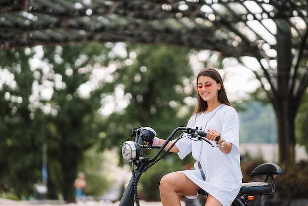 Mujer hermosa joven y un scooter eléctrico
