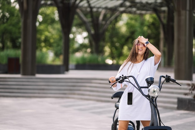 Mujer hermosa joven y un scooter eléctrico