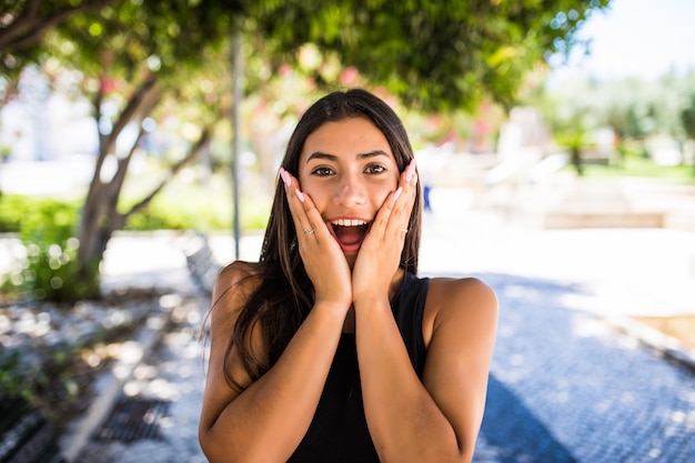 Foto gratuita mujer hermosa joven sorprendida en la calle de la ciudad. conmoción por algunas noticias. es hermosa y guapa, joven y divertida. ella camina por la calle y tiene buen humor