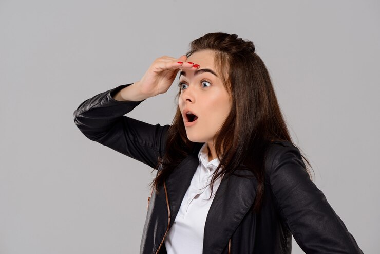 Foto gratuito mujer hermosa joven sorprendida posando, mirando a otro lado sobre la pared púrpura