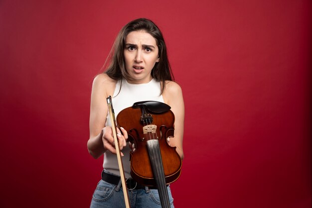 Mujer hermosa joven sosteniendo un violín