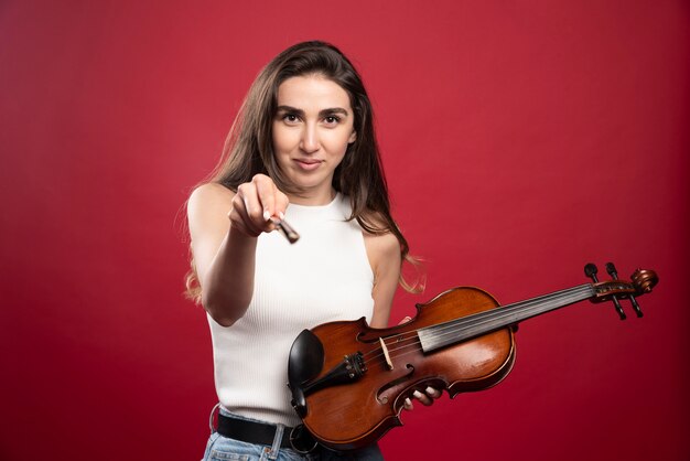 Mujer hermosa joven sosteniendo un violín