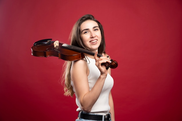Mujer hermosa joven sosteniendo un violín