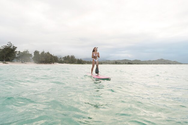Mujer hermosa joven surfeando en hawaii