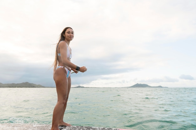Mujer hermosa joven surfeando en hawaii