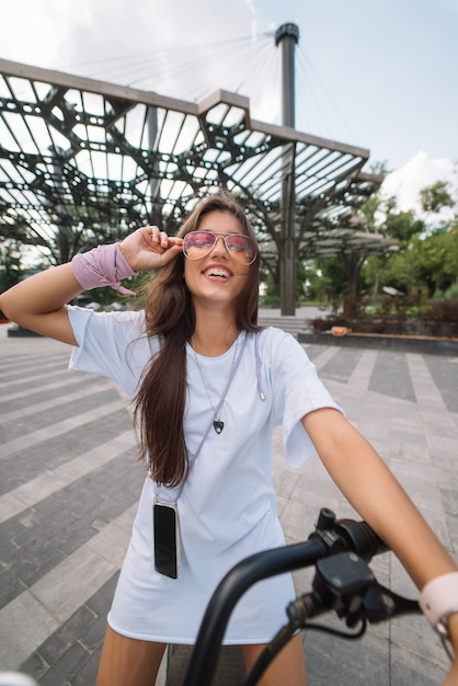 Mujer hermosa joven y un transporte ecológico scooter eléctrico