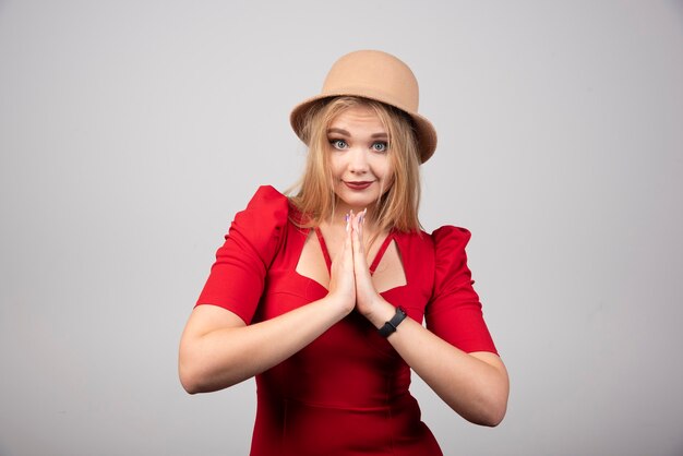 Mujer hermosa joven en vestido rojo rezando.