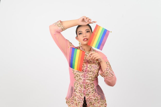 Mujer hermosa joven vestirse en la cultura local en la región sur con la bandera del arco iris