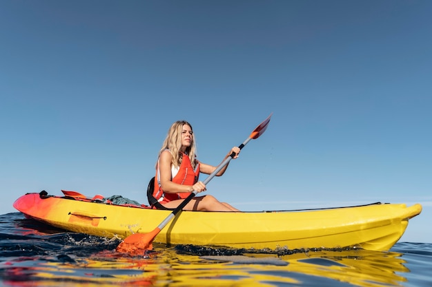Mujer hermosa joven viajando en canoa