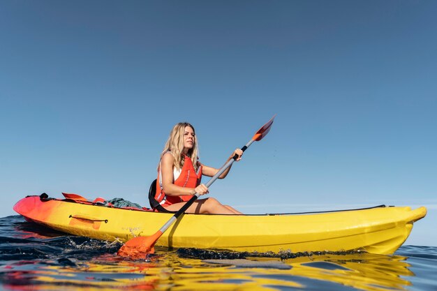 Mujer hermosa joven viajando en canoa