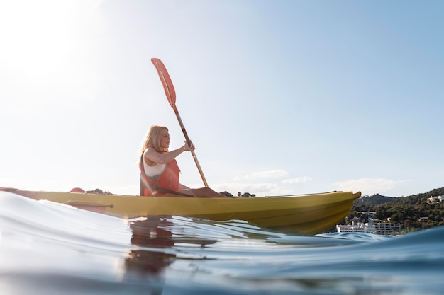 Mujer hermosa joven viajando en canoa