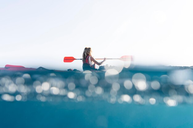 Mujer hermosa joven viajando en canoa