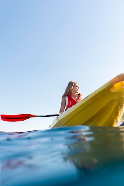 Mujer hermosa joven viajando en canoa