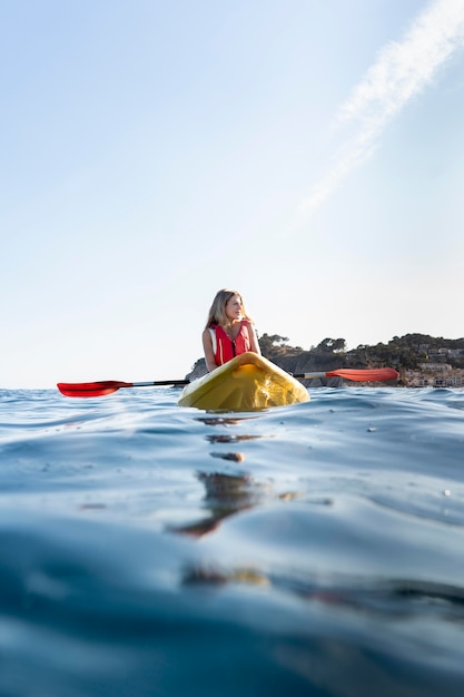 Mujer hermosa joven viajando en canoa