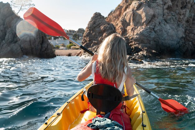 Mujer hermosa joven viajando en canoa