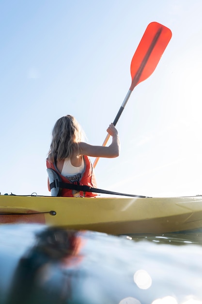 Foto gratuita mujer hermosa joven viajando en canoa