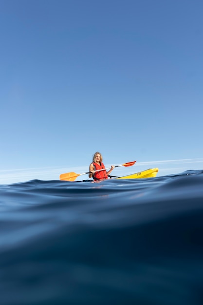 Mujer hermosa joven viajando en canoa