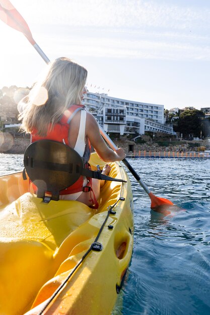 Mujer hermosa joven viajando en canoa