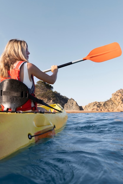 Mujer hermosa joven viajando en canoa