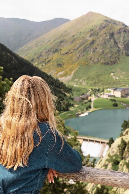 Mujer hermosa joven viajando en las montañas