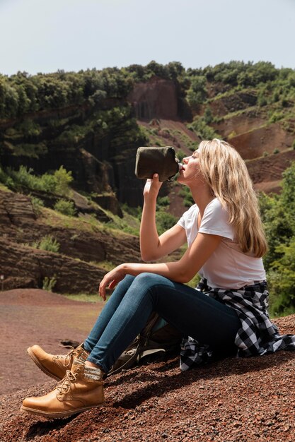 Mujer hermosa joven viajando en las montañas