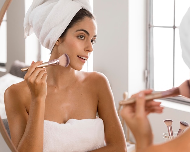 Mujer hermosa joven con una vista frontal del cepillo de maquillaje