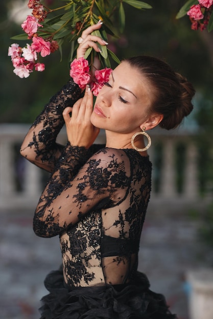 mujer hermosa de moda en vestido de lujo negro al aire libre