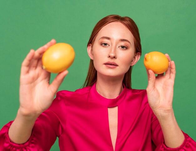 Mujer hermosa pelirroja posando con frutas