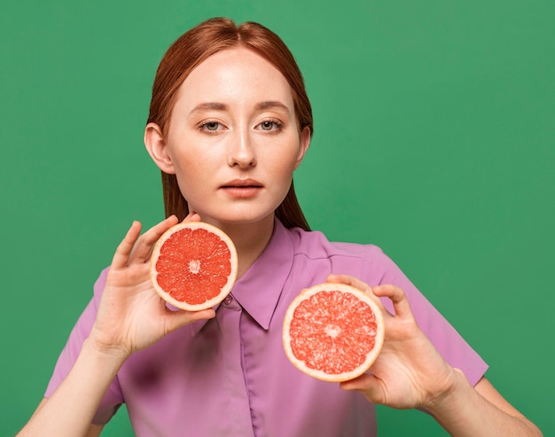 Foto gratuita mujer hermosa pelirroja posando con frutas