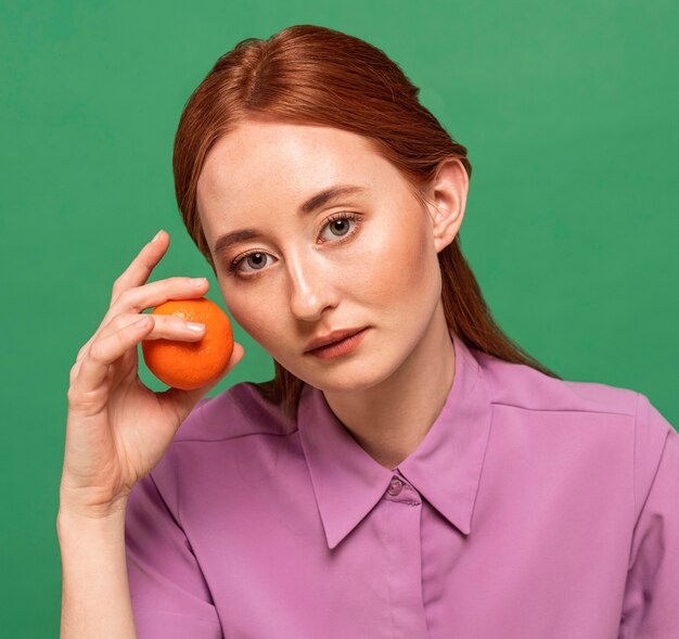 Mujer hermosa pelirroja posando con naranjas