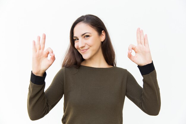 Mujer hermosa positiva alegre que hace gesto aceptable