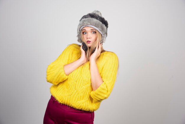 Mujer hermosa en la presentación del suéter amarillo.