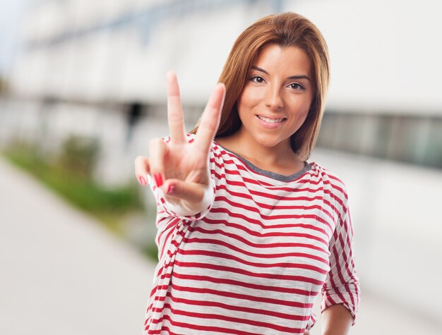 Mujer hermosa que muestra signo de la paz