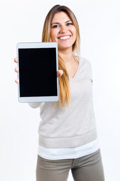 Mujer hermosa que muestra la tableta digital. Aislado en blanco.