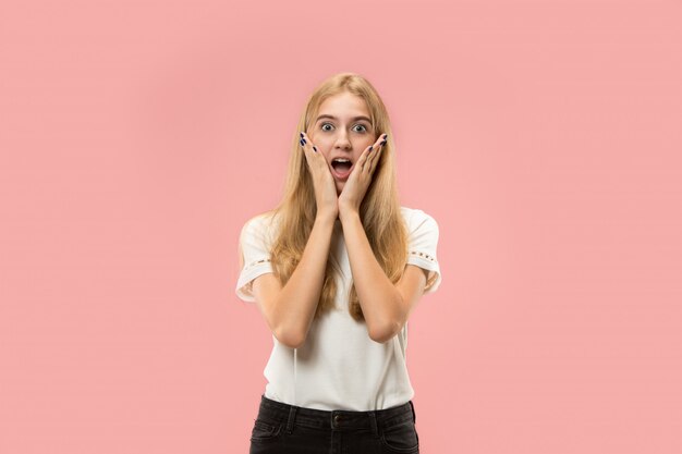 Mujer hermosa que parece sorprendida aislada en la pared rosada