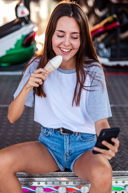 Mujer hermosa que sostiene el helado que toma el selfie