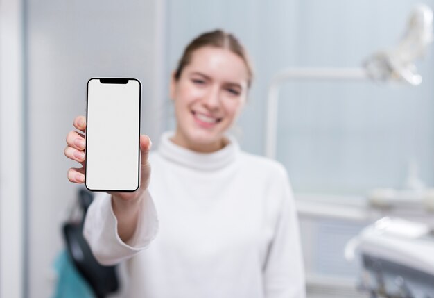 Mujer hermosa que sostiene el teléfono móvil