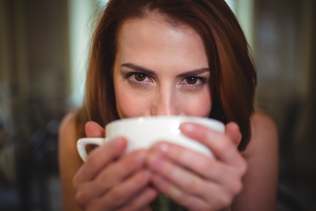 Foto gratuita mujer hermosa que tiene una taza de café en la cafetería ©