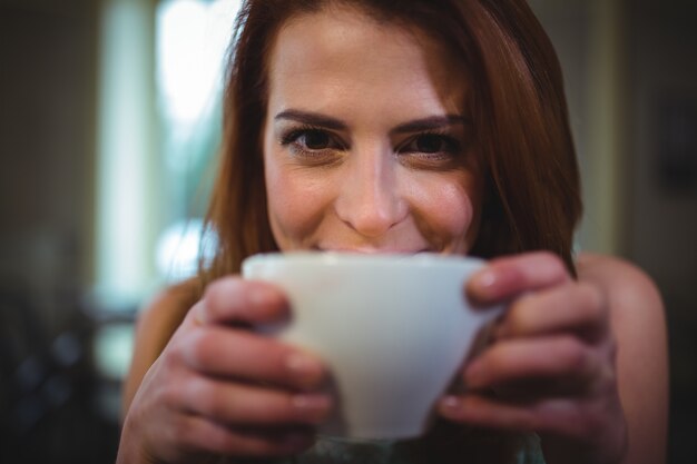 Mujer hermosa que tiene una taza de café en la cafetería ©