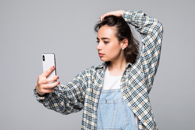 Mujer hermosa sociable con apariencia asiática tomando selfie o hablando por videollamada con teléfono celular aislado