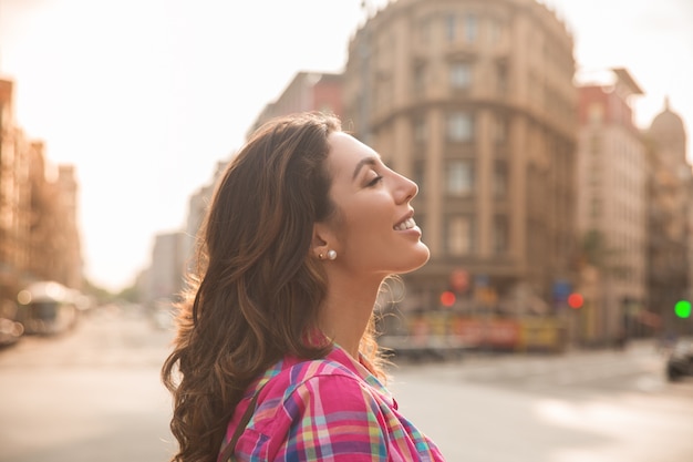 Mujer hermosa soñadora disfrutando de la vida de la ciudad