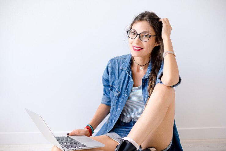 Foto gratuito mujer hermosa sonriente en vidrios con la computadora portátil