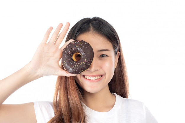 Mujer hermosa con una sonrisa feliz que celebra un buñuelo de la mano, aislado en el fondo blanco.