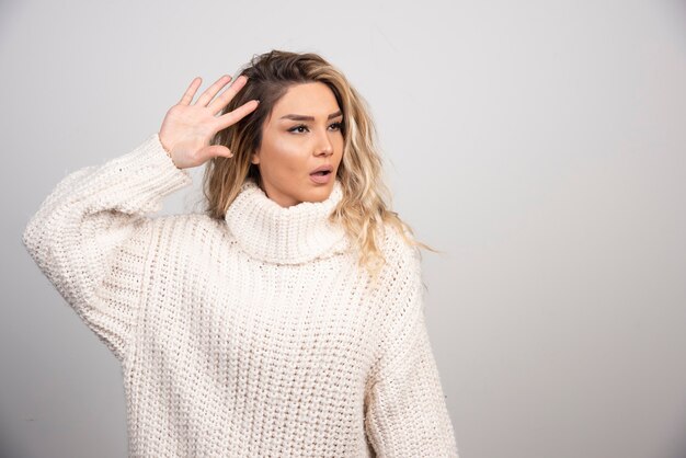 Mujer hermosa en suéter de invierno mostrando su mano.