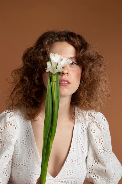 Mujer con hermosas flores de gladiolo