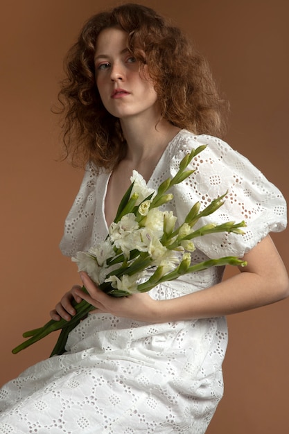 Foto gratuita mujer con hermosas flores de gladiolo